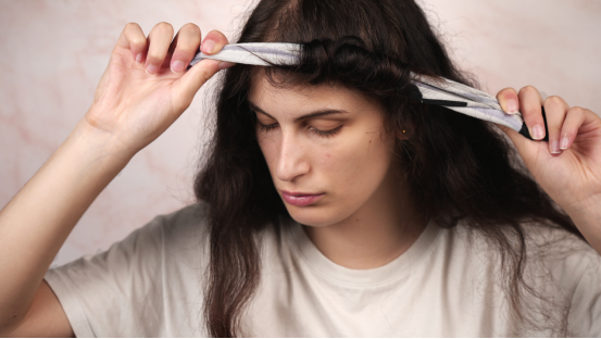 A woman using a heatless hair curler, showcasing the easy 10-minute morning routine to achieve curls.