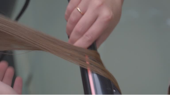 Woman styles hair with a heatless hair curler, embracing sustainable beauty with effortless curls