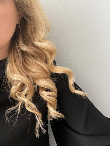 Woman with curly blonde hair, styled without a heatless hair curler