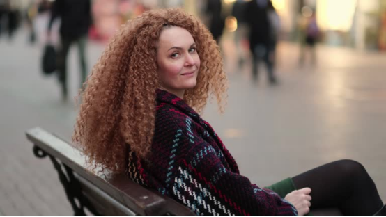 Woman with voluminous, defined curls, showcasing the result of using a heatless hair curler for frizz-free, smooth curls