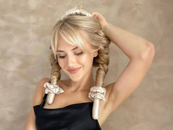 Blonde woman with twin braid curls (created via a heatless hair curler), a style tailored to complement specific face shapes.