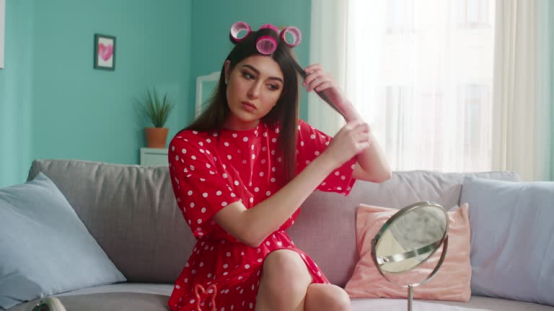 A woman styles her hair with a heatless hair curler, crafting perfect curls for a special occasion.